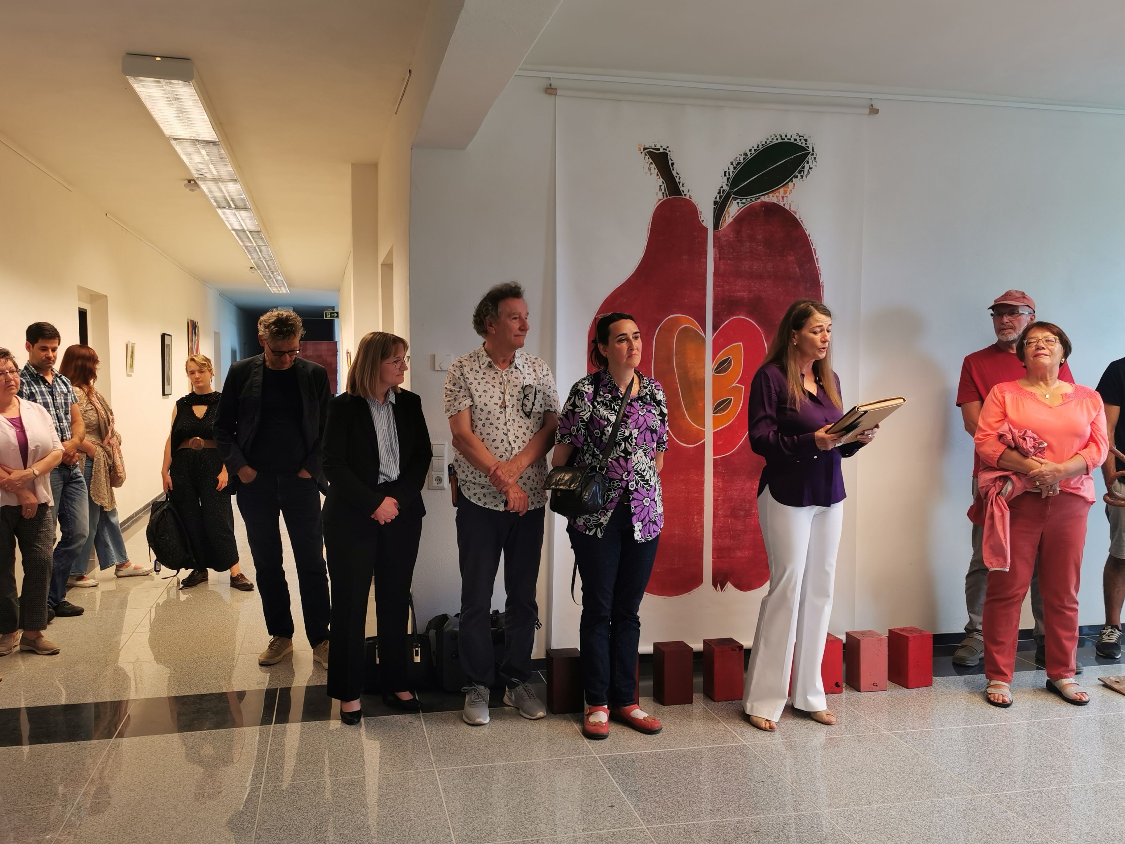 Sabine Kunz vor dem Farbholzschnitt ApfelBirne anlässlich der Eröffnung der Ausstellung Kunstwochen in Radewell 2022
